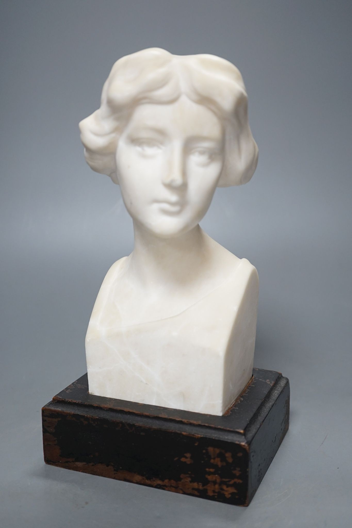 An alabaster head of a woman on plinth 25cm